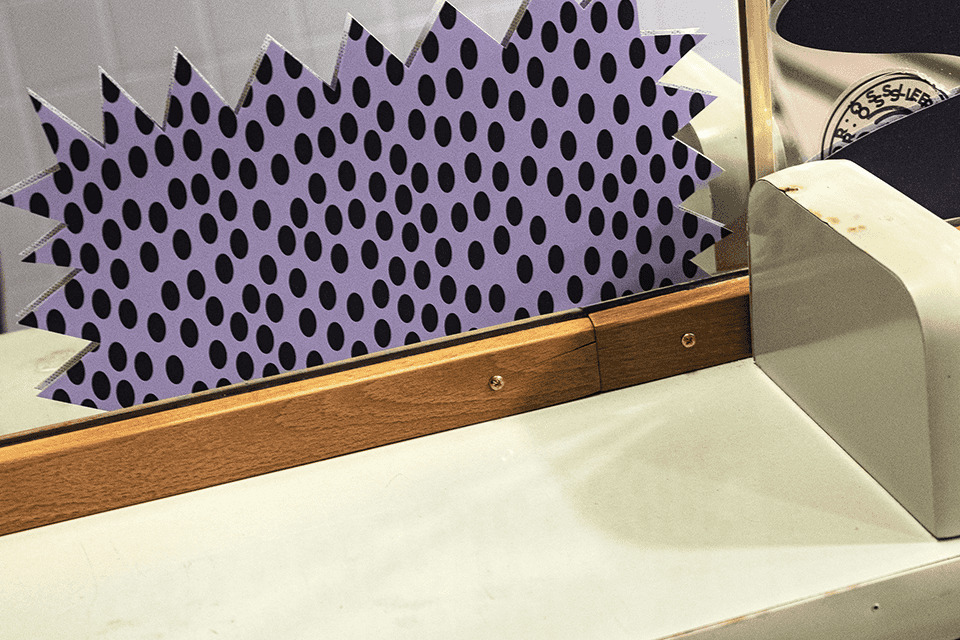 Viva con Agua Toilette: Spiegel mit lila Punktmuster und Holzelementen. Kunstinstallation.