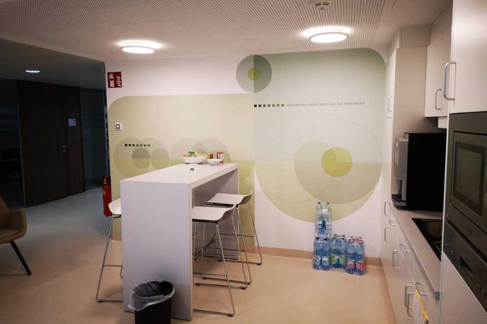 SVS INTERIORS: Plakative Wandbeklebung im Gesundheitszentrum. Design mit Kreisen, Küchenzeile, minimalistisch.