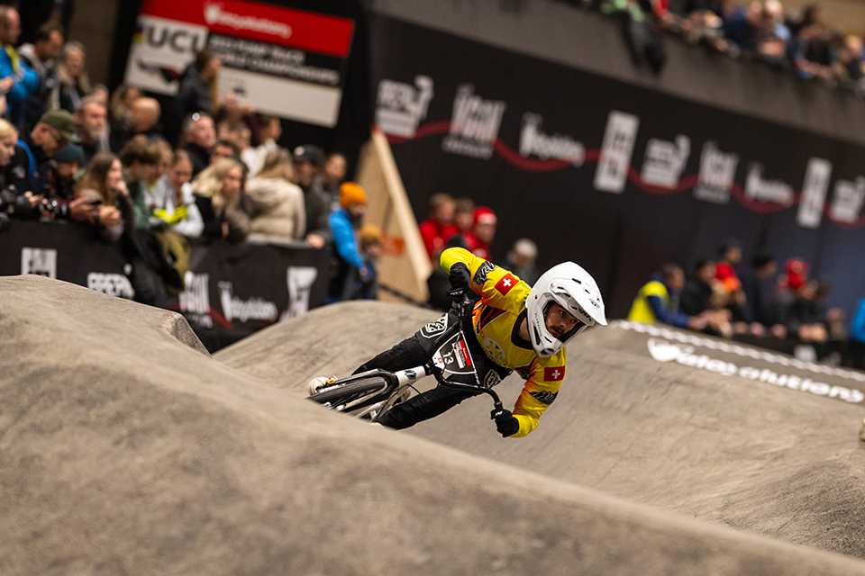 UCI Pump Track WM Tirol: Fahrer auf der Strecke. Zuschauer im Hintergrund.