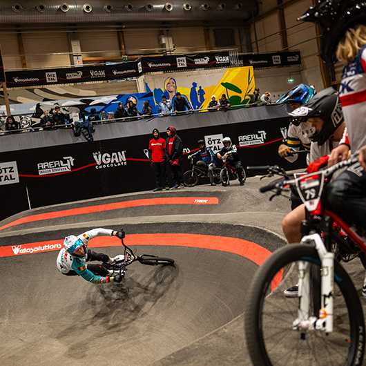UCI Pump Track WM Tirol: BMX-Fahrer auf der Strecke. Zuschauer und Team-Mitglieder.